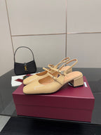Beige patent leather slingback pump with ankle strap and decorative charm