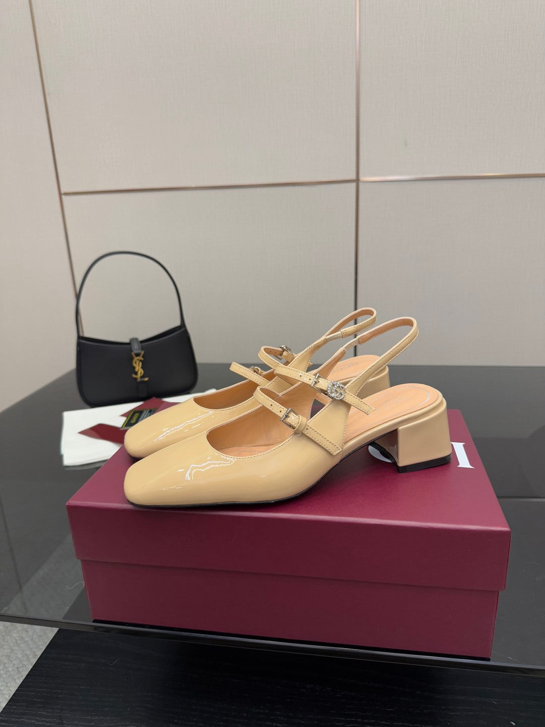 Beige patent leather slingback pump with ankle strap and decorative charm