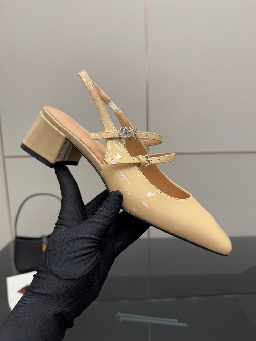 Beige patent leather slingback pump with ankle strap and square low block heel