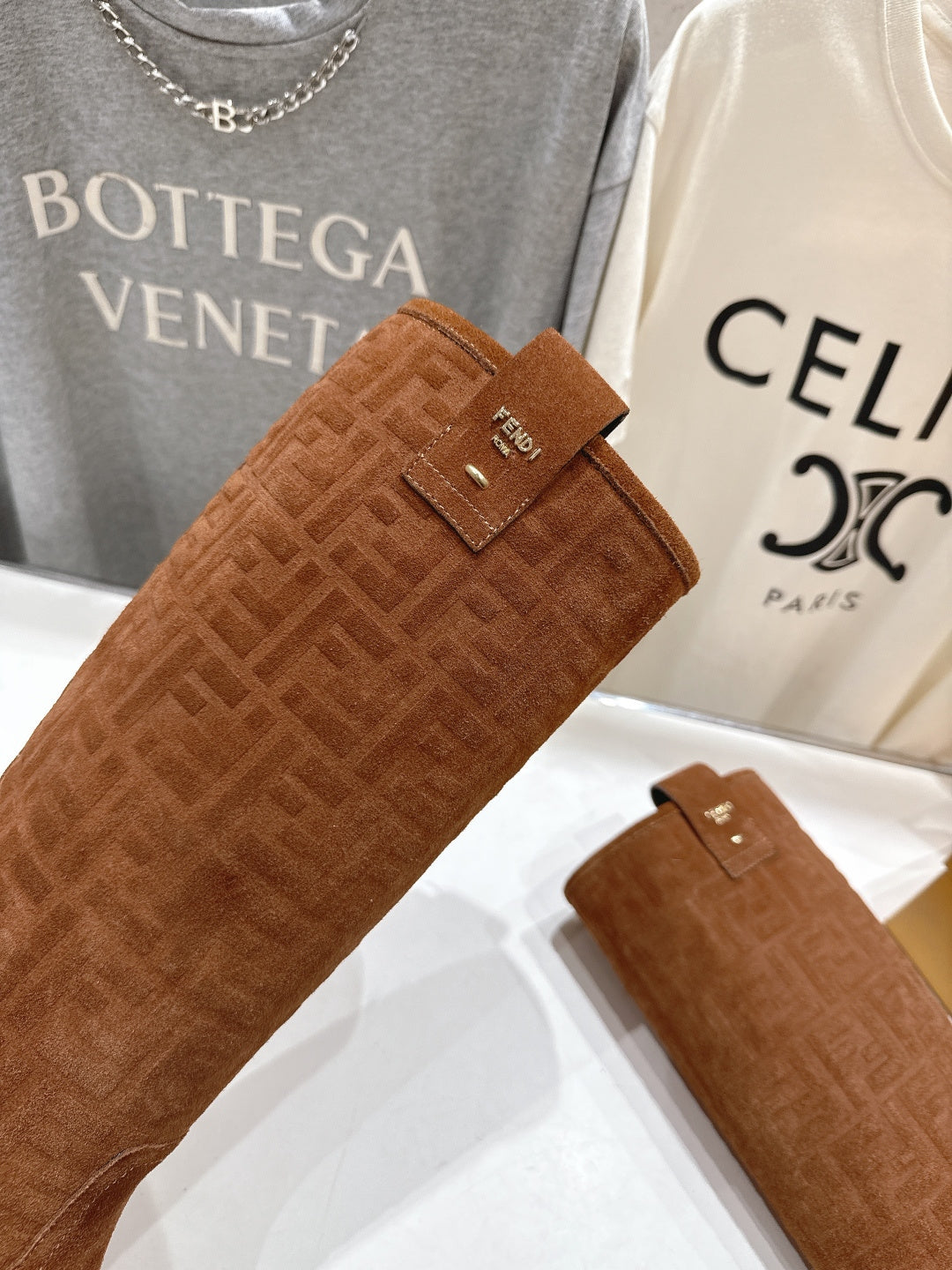 Brown suede boot shaft with small Fendi tag and textured FF pattern