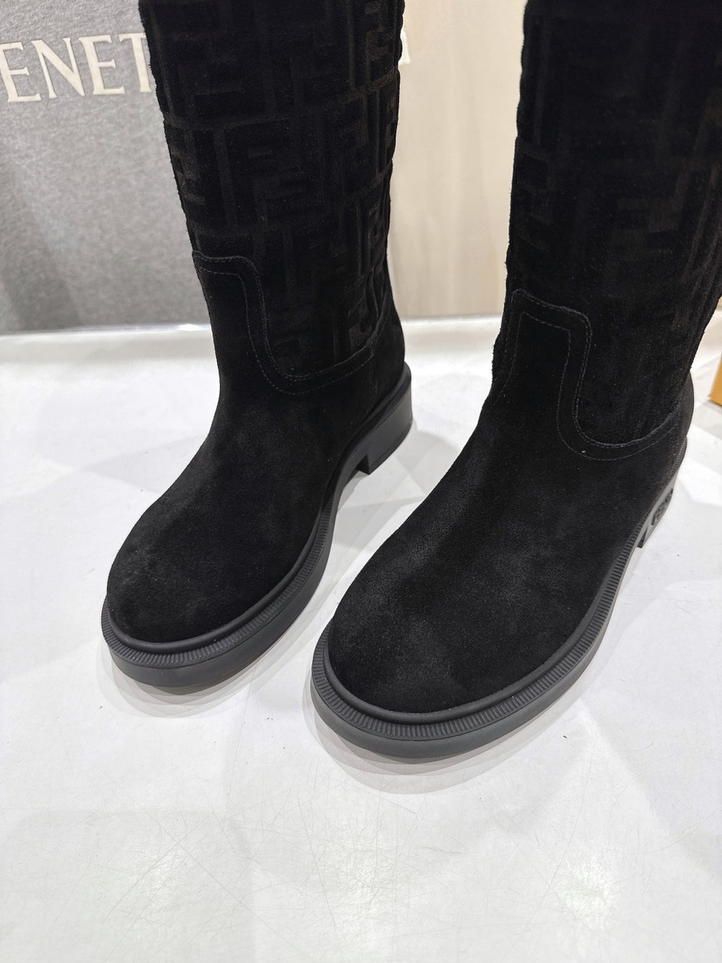 Black knee-high boots with stitched panels and flat, grippy sole