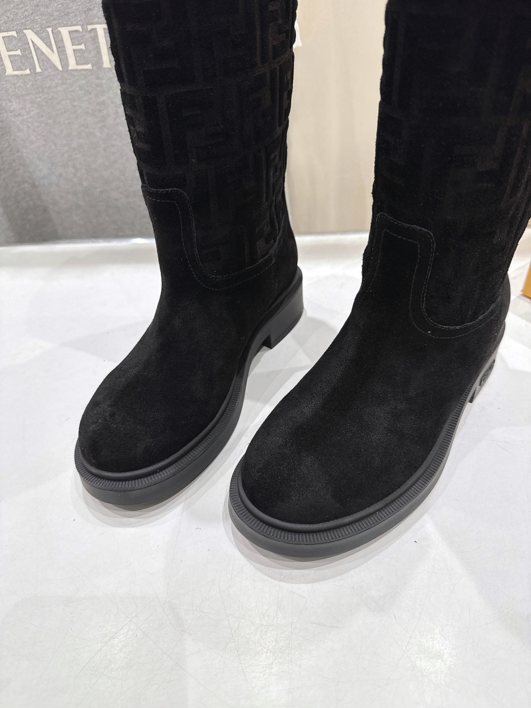 Black knee-high boots with stitched panels and flat, grippy sole