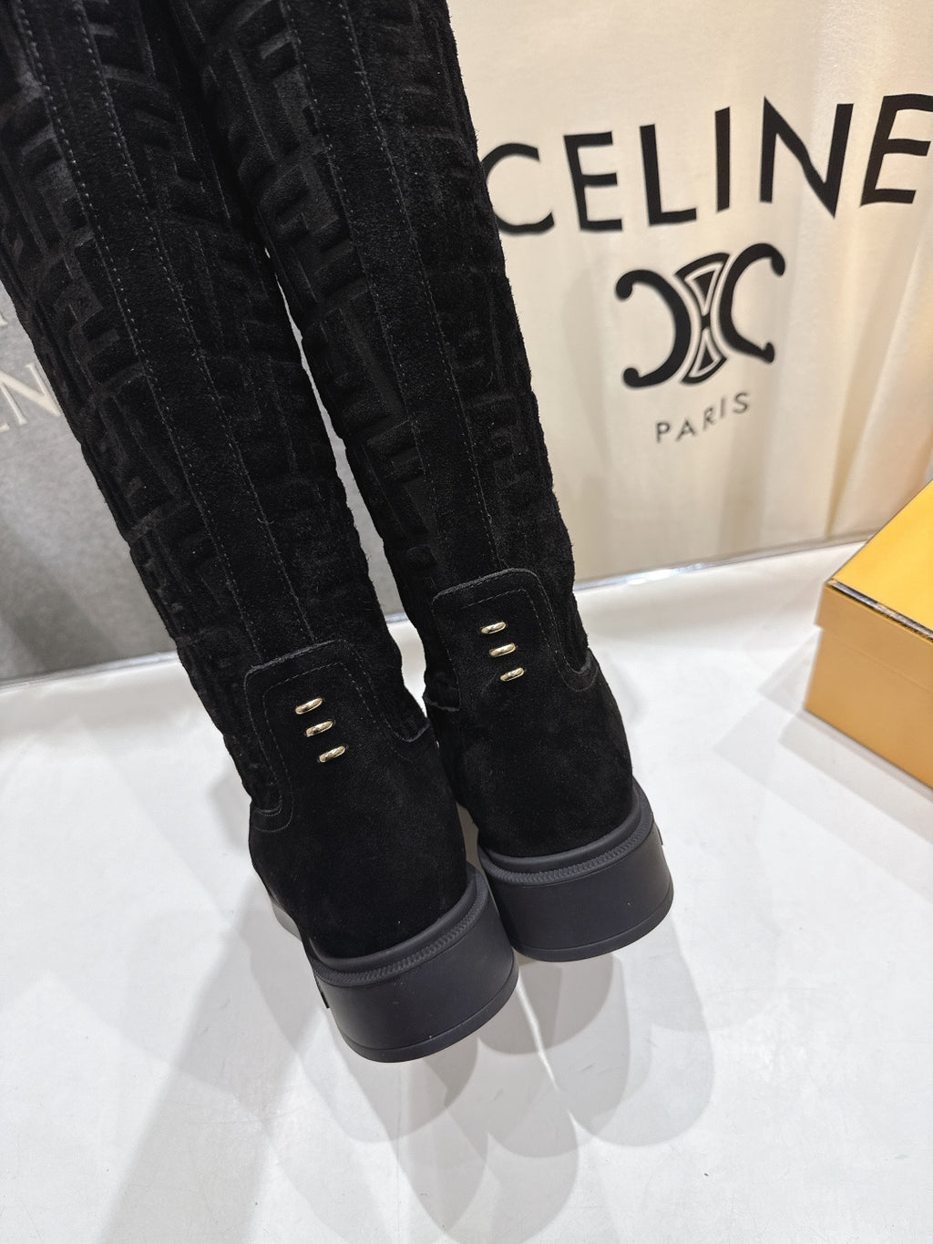 Black knee-high boots close-up with back seam detail and gray rubber sole