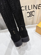 Black knee-high boots close-up with back seam detail and gray rubber sole
