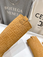 Tan suede knee-high boots close-up, buckle tab and woven-texture upper
