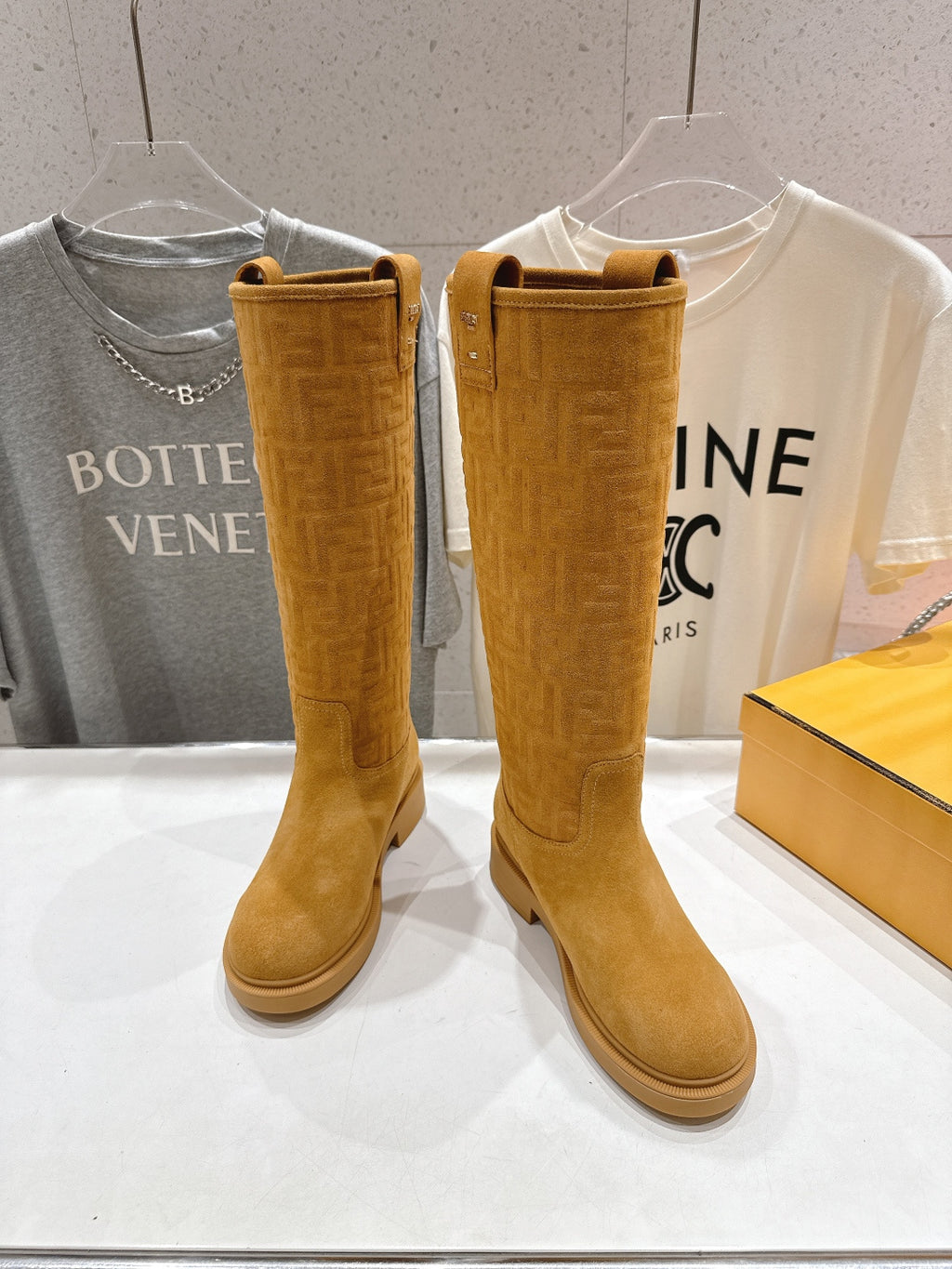 Tan knee-high pull-on boots with stitched detail and low flat sole