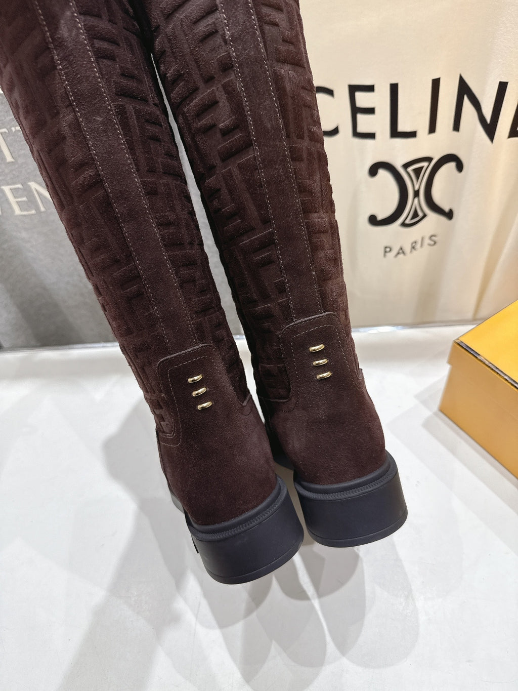 Burgundy tall boots with gold-tone eyelets and dark rubber sole