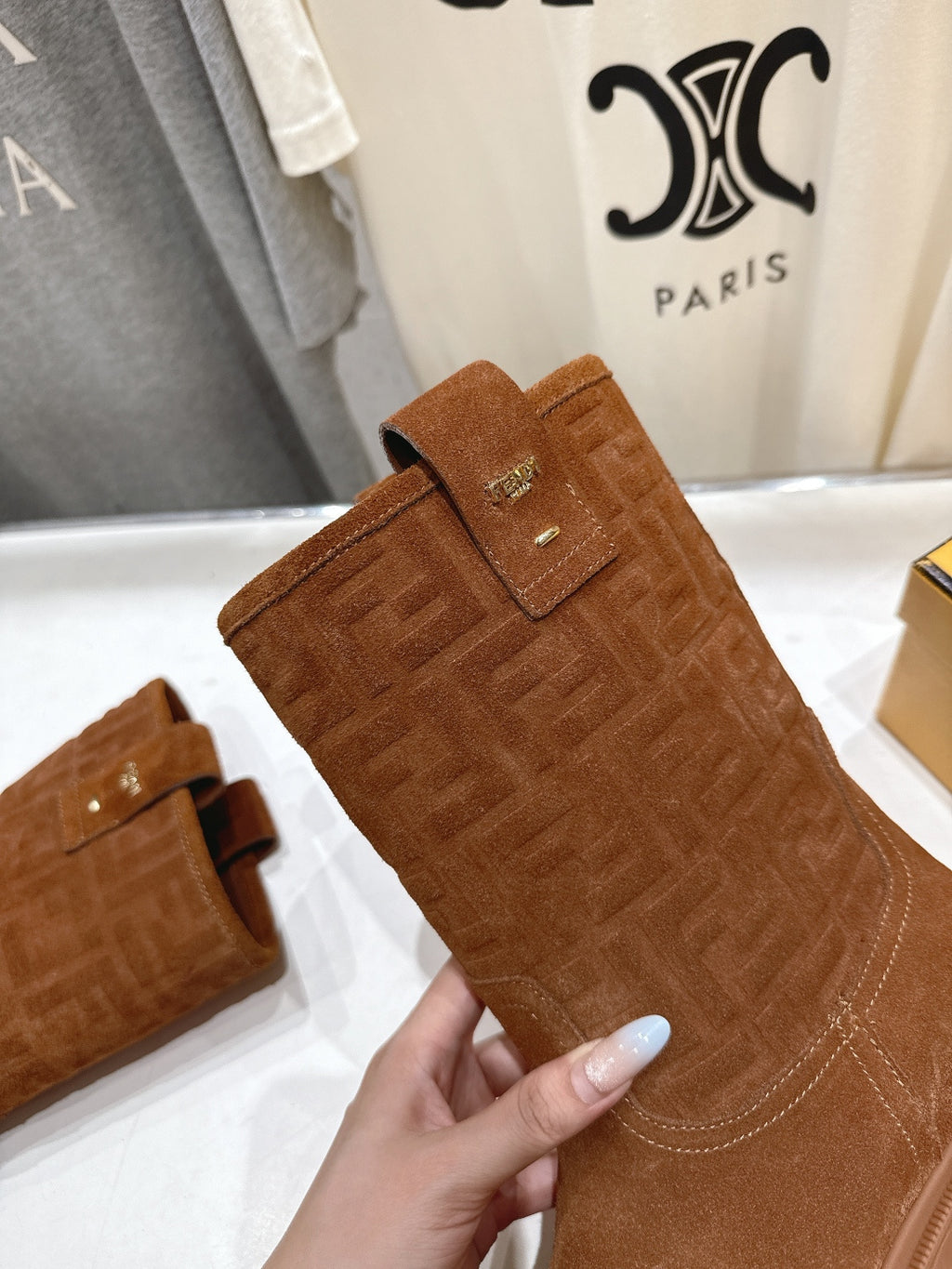 Brown Fendi suede mid-calf boot close-up, embossed logo panel and strap detail