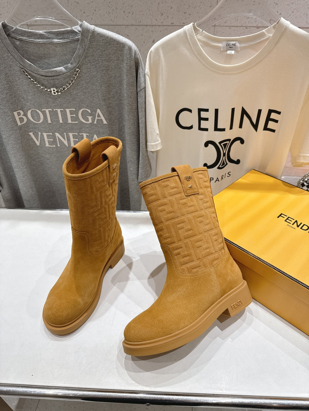Women’s tan suede ankle boots with side pull tab and embossed logo finish