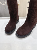 Close-up of brown suede ankle boots with rubber sole and stitched cuff