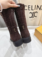 Brown suede tall ankle boots held up, showing embossed Fendi logo