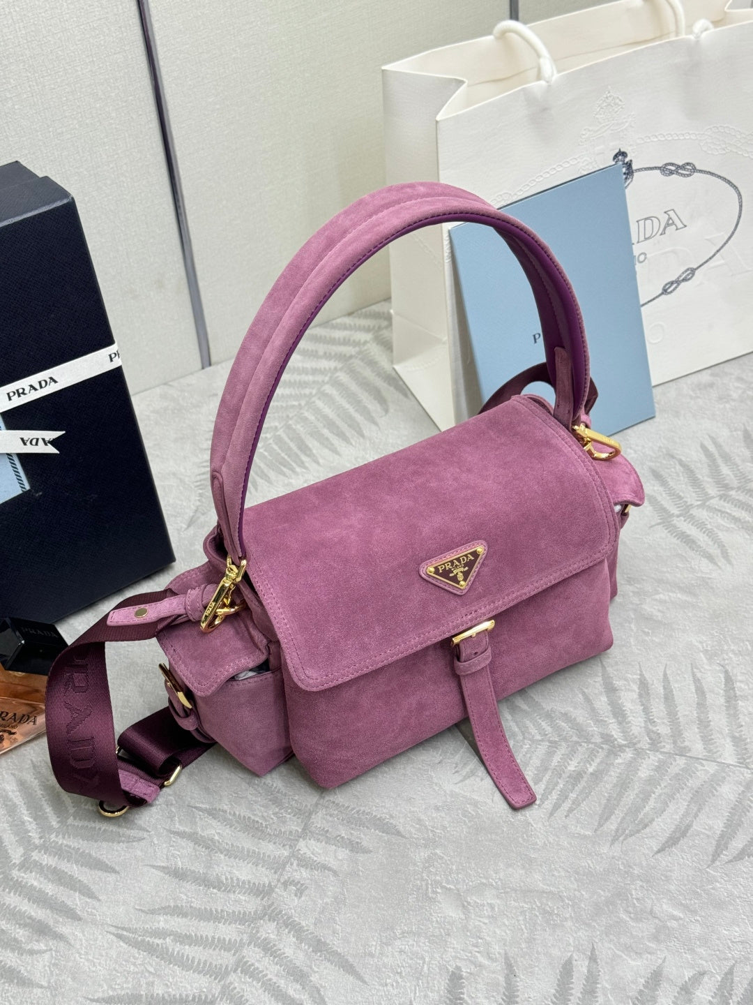 Purple suede flap shoulder bag with gold-tone hardware and adjustable crossbody strap