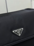 Black Prada logo triangle patch on nylon fabric with stitched trim