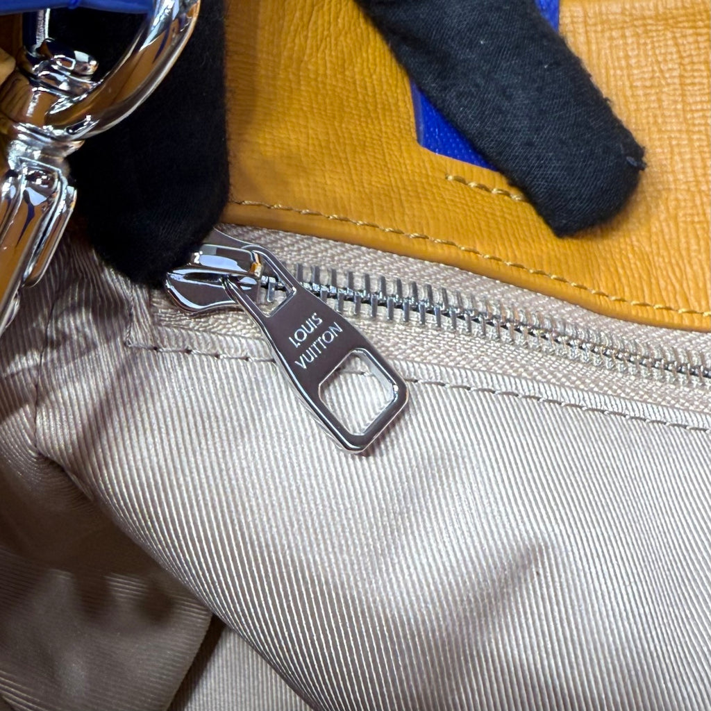 Tote zipper pull with Louis Vuitton emblem and striped fabric lining detail