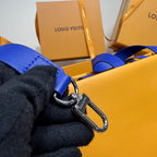 Yellow leather bag with metal clasp and blue strap loop on side