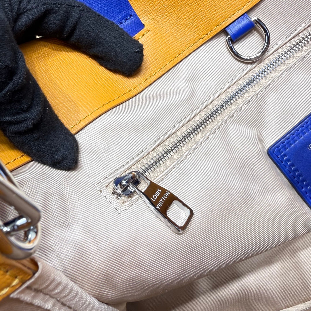 Light gray fabric lining with silver zipper and metal pull on yellow bag