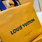 Yellow leather tote bag close-up with Louis Vuitton logo and small text