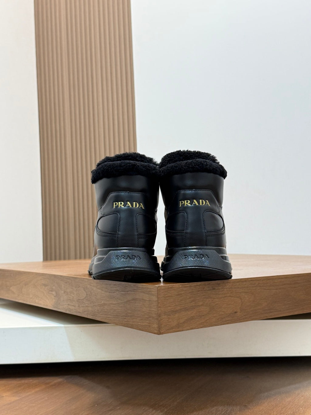 Back view of Prada dark leather winter sneakers with shearling heel lining and lace-up tops