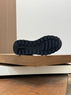 Outsole tread view of Prada dark winter sneakers, rugged rubber pattern