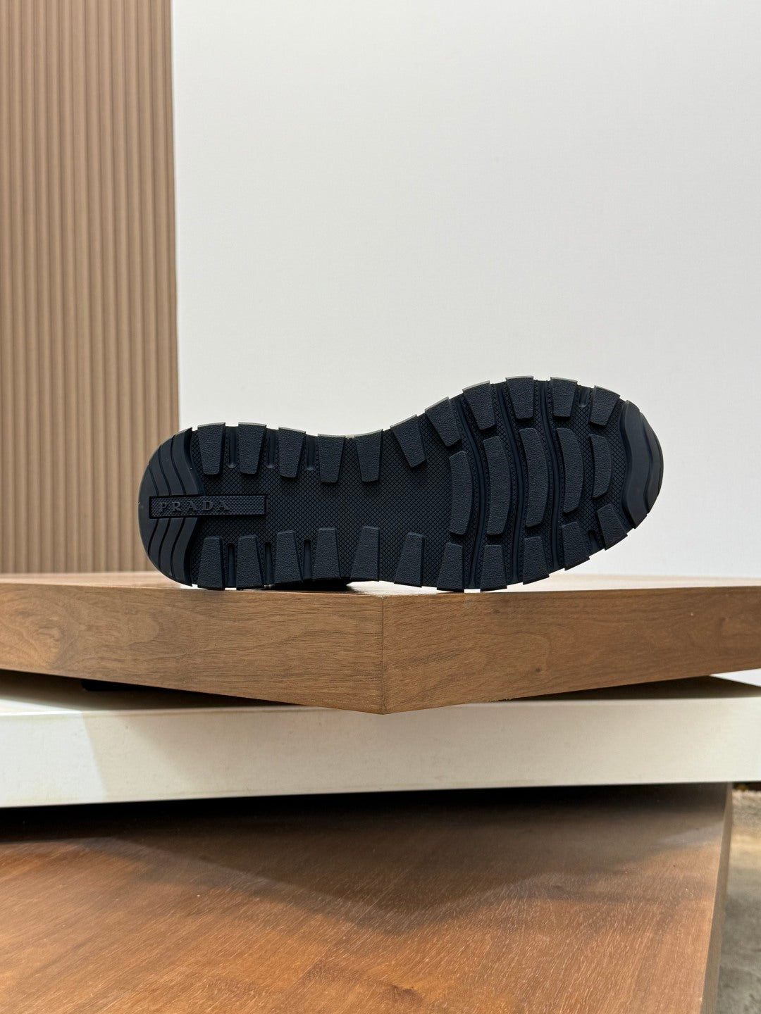 Outsole tread view of Prada dark winter sneakers, rugged rubber pattern