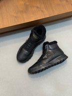 Two Prada dark leather winter sneakers, one side view showing shearling collar and tread sole