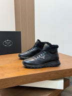 Pair of Prada dark leather winter sneakers on a shelf, lace-up design with shearling trim