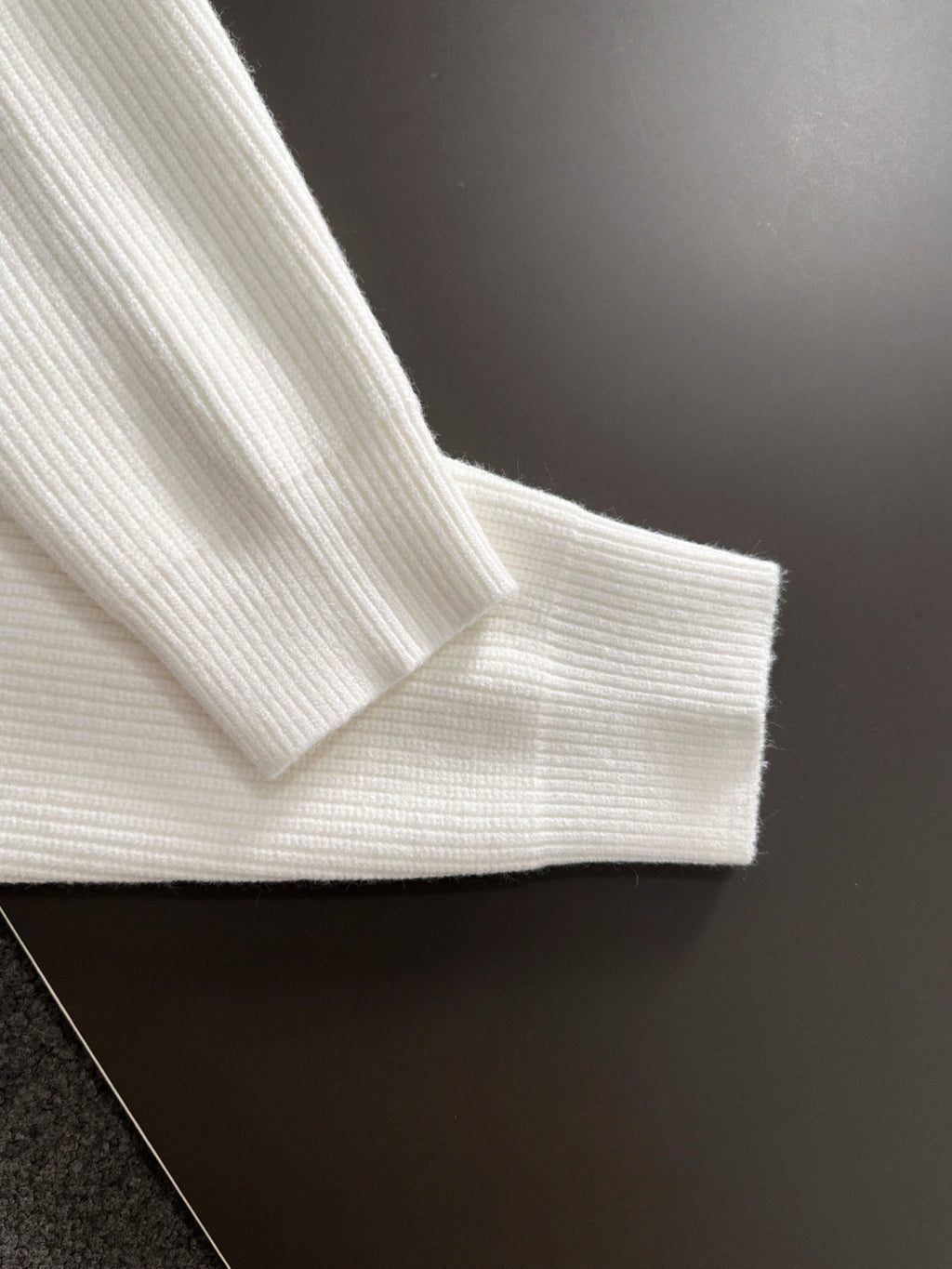 White knit sweater sleeve cuff and shoulder seam