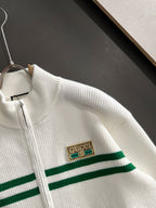 White knit sweater with green stripe band and Gucci logo patch