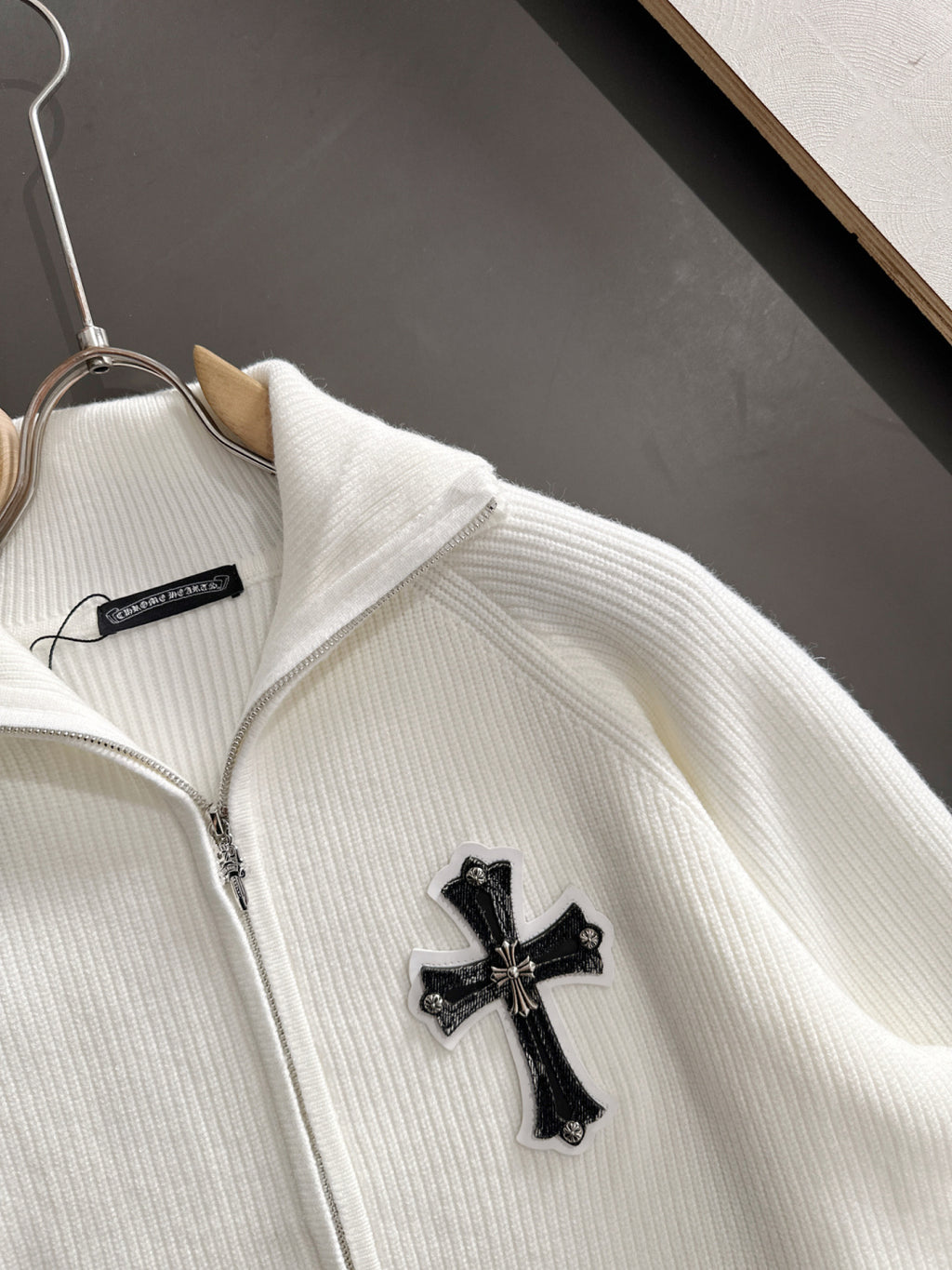 White zip jacket with cross applique at chest and stand collar