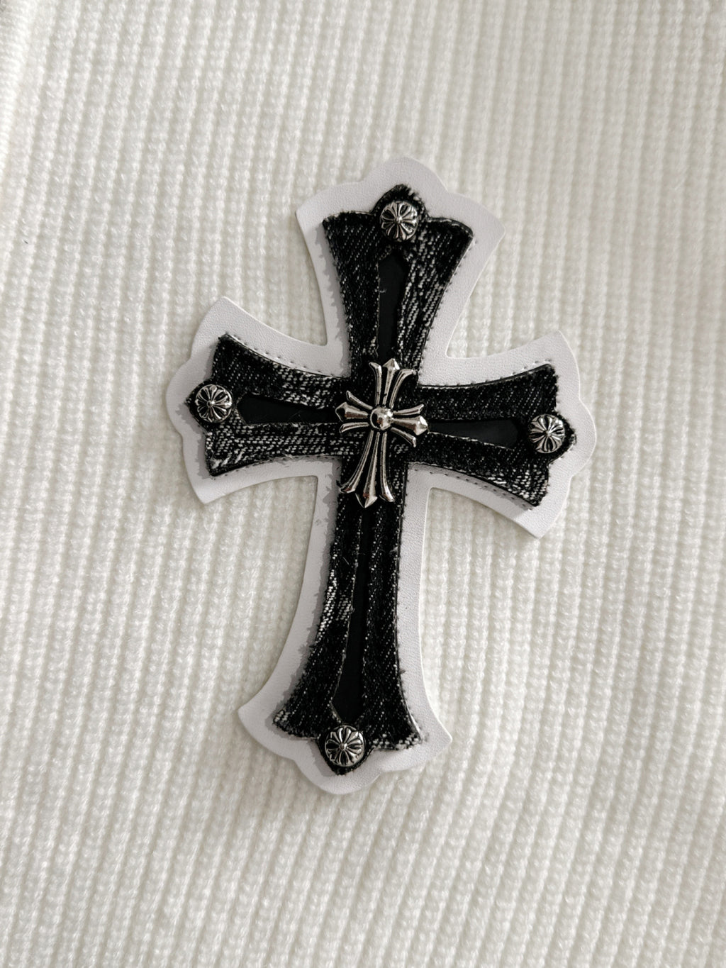 Embroidered black cross applique patch with textured details