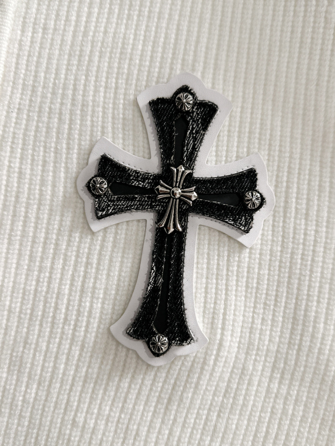 Embroidered black cross applique patch with textured details