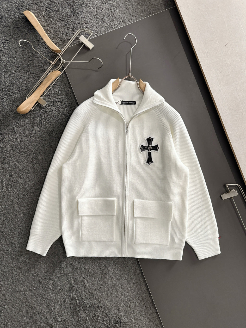 White long-sleeve zip jacket with cross applique and chest flap pockets