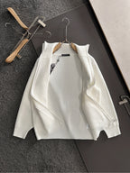 White long-sleeve zip jacket with cross applique, zipper, and ribbed knit texture