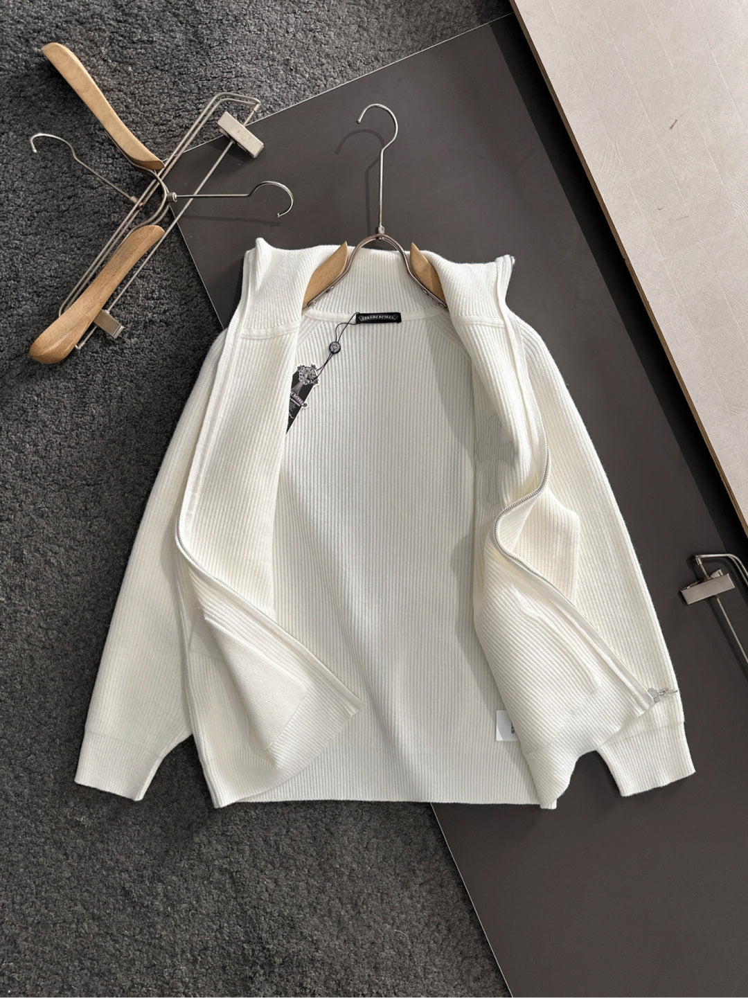 White long-sleeve zip jacket with cross applique, zipper, and ribbed knit texture