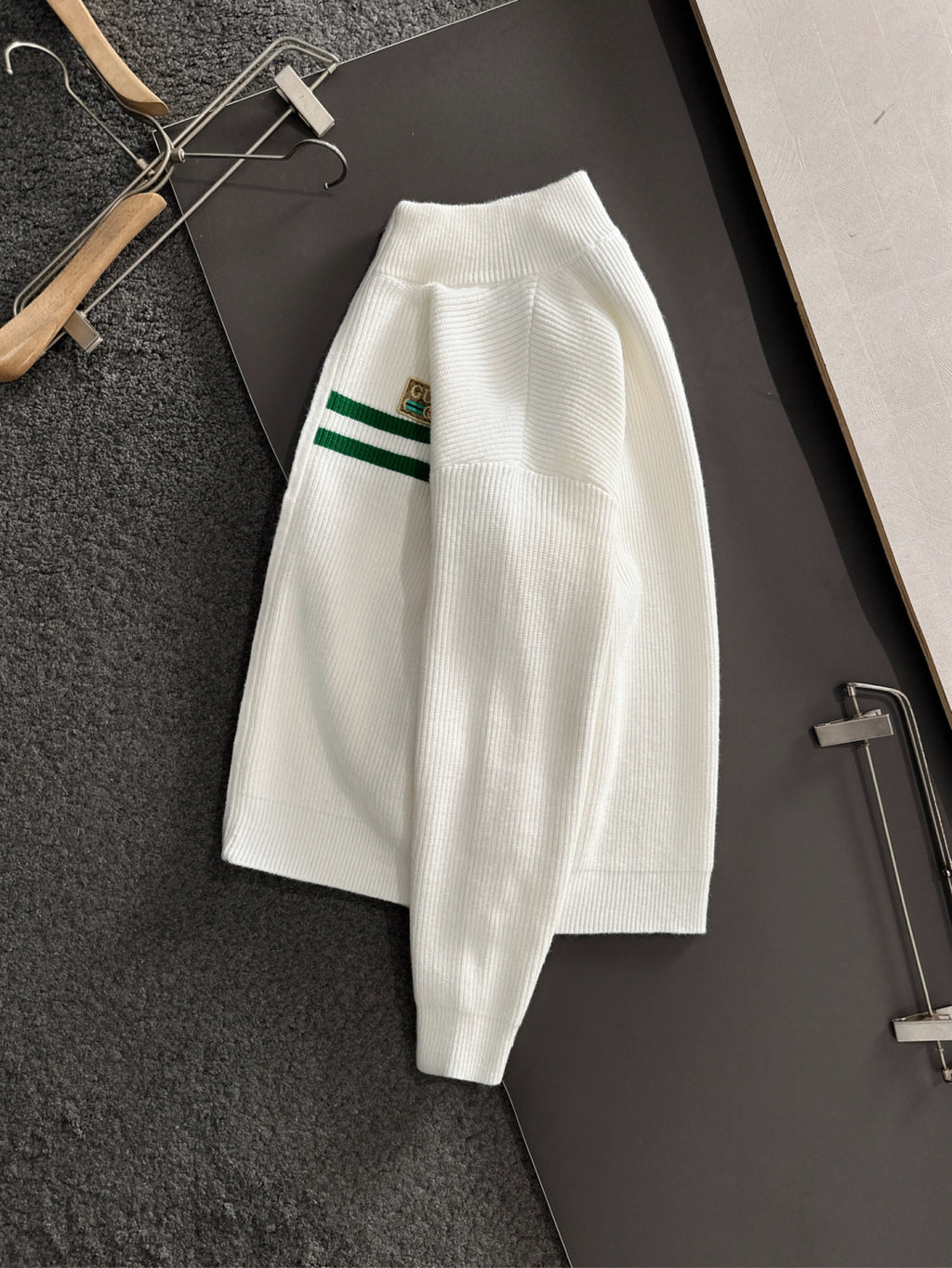White long-sleeve knit sweater with green stripe sleeve detail