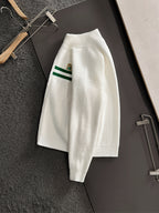 White long-sleeve knit sweater with green stripe sleeve detail