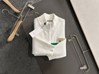 White long-sleeve knit sweater with green stripe, logo patch detail