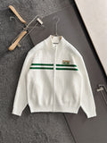 White zip knit sweater with green stripe band and logo patch
