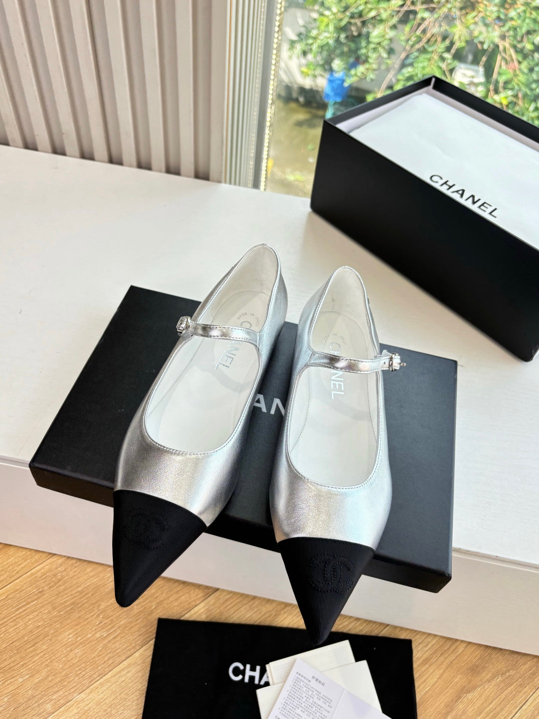 Women’s Chanel silver dress flats with black toe inserts and decorative buckle strap