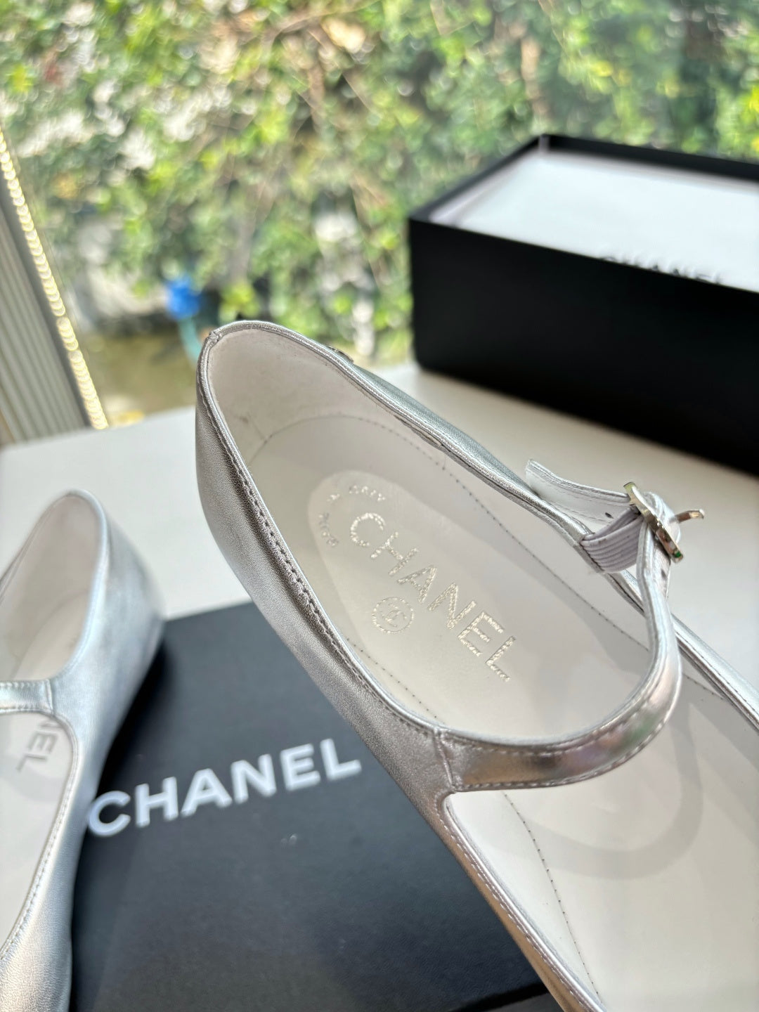 Women’s Chanel flat showing silver insole with logo, black toe cap