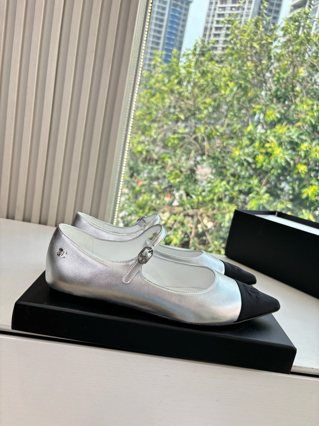 Women’s Chanel silver Mary Jane flats with black toe cap and buckle strap