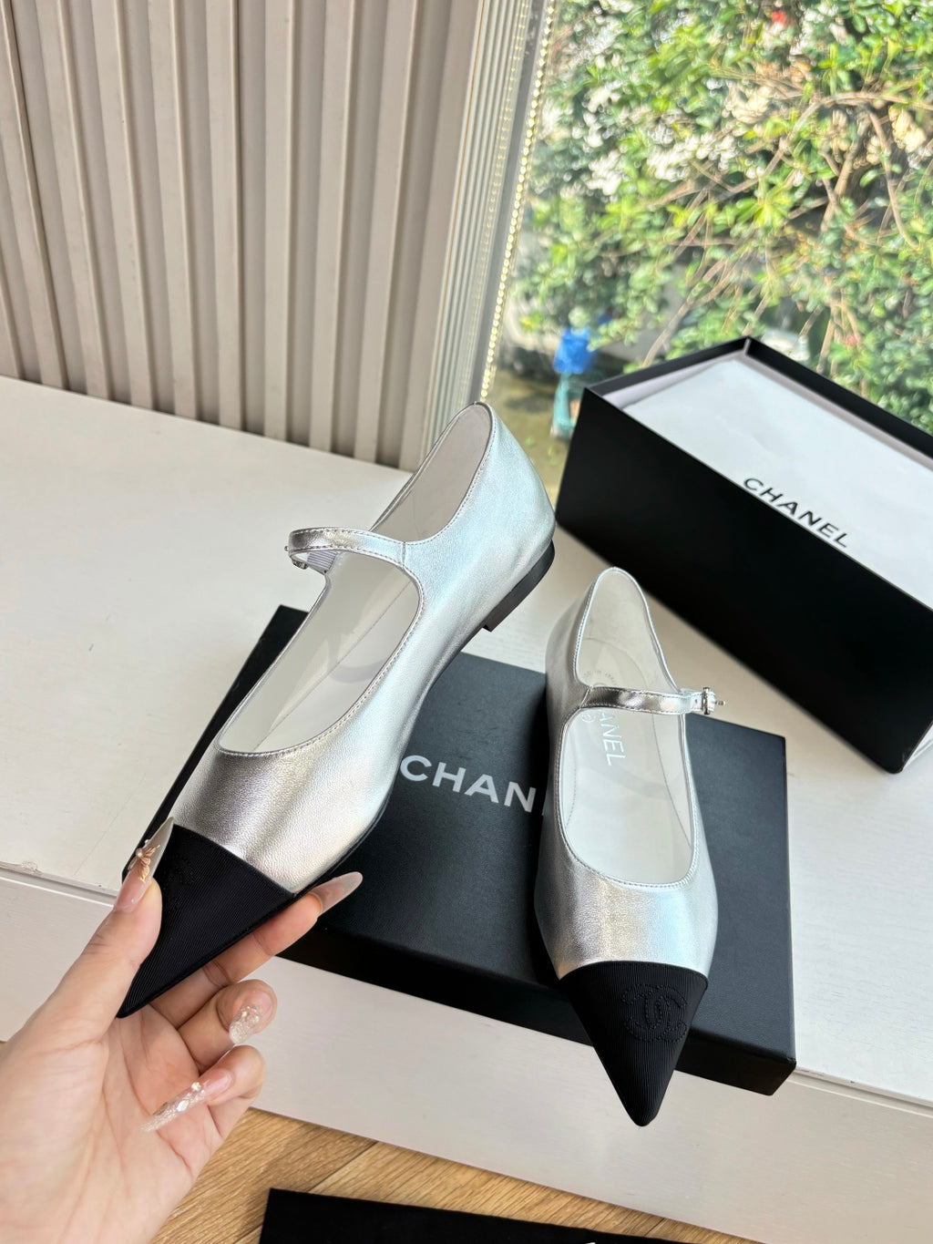 Women’s Chanel silver two-tone flats with black toe inserts and strap buckle