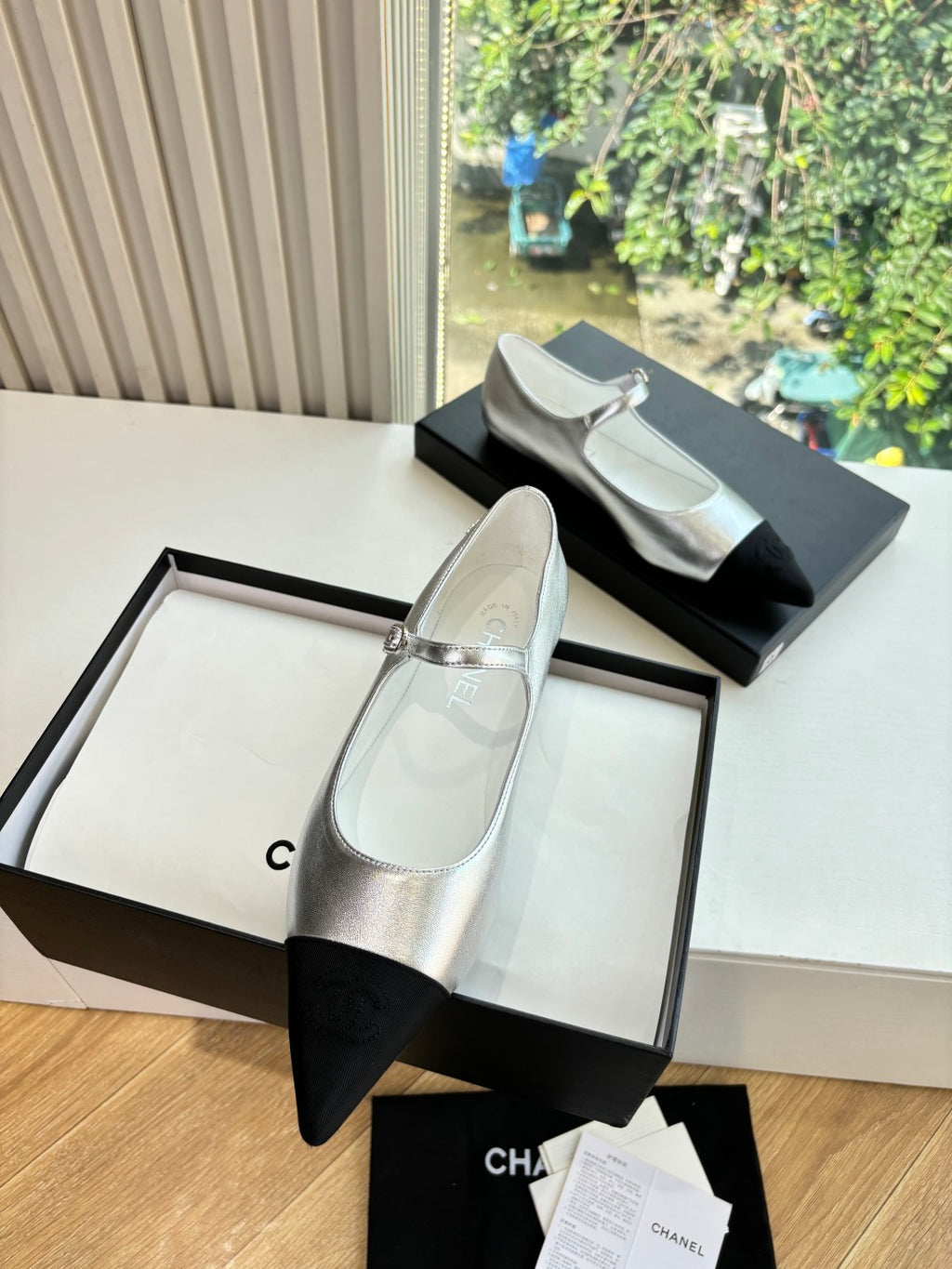 Women’s Chanel two-tone dress flats with silver uppers and black pointed toes