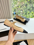 Beige pointed-toe flats with black toe sections and a thin ankle strap