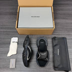 Black sandals with curved straps and thick sole, angled view of the pair.