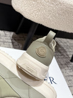 Moncler slip-on shoe heel detail in light olive with circular logo patch.