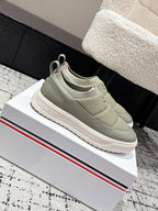 Moncler slip-on shoes in light olive with rear logo badge and cushioned sole.