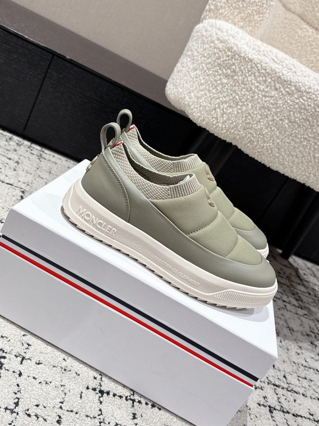 Moncler slip-on shoes in light olive with rear logo badge and cushioned sole.