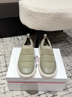 Moncler slip-on shoes in light olive with elastic side panels and round toe.
