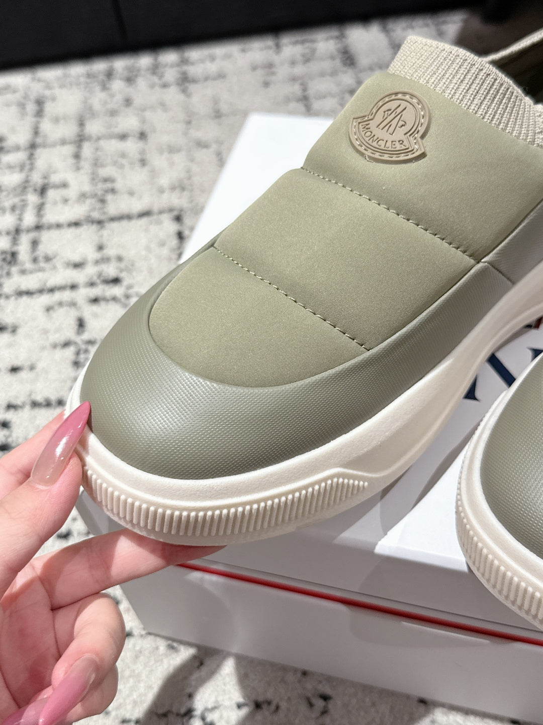 Moncler slip-on shoe in light olive with ribbed sole edge and elastic collar.